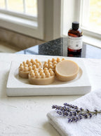 Cashmere Cedar artisan massage soap bars in warm natural beige on a white stone tray with lavender