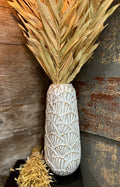 Decorative Vase with dried leaves against a rustic wooden background