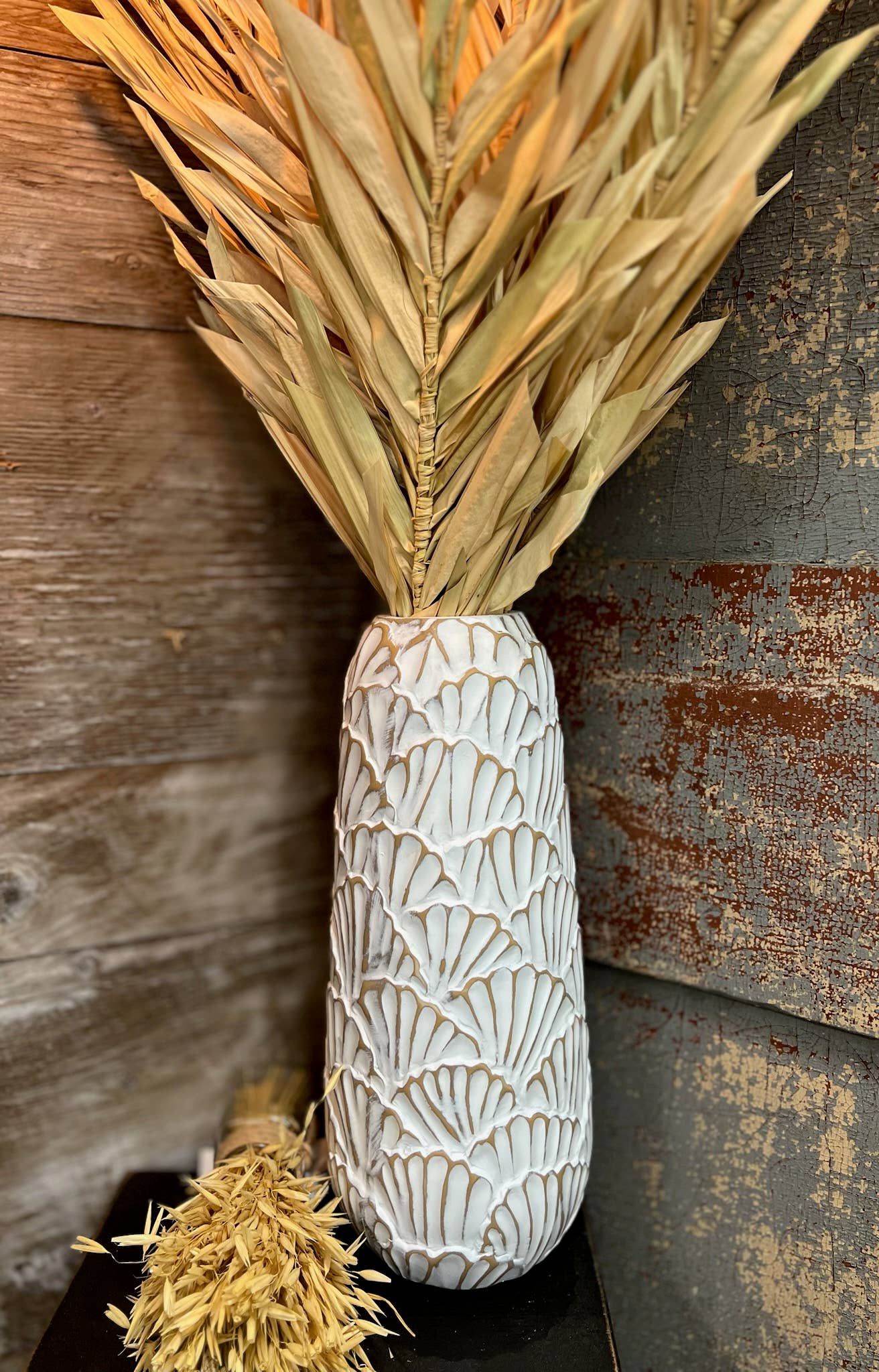 Decorative Vase with dried leaves against a rustic wooden background