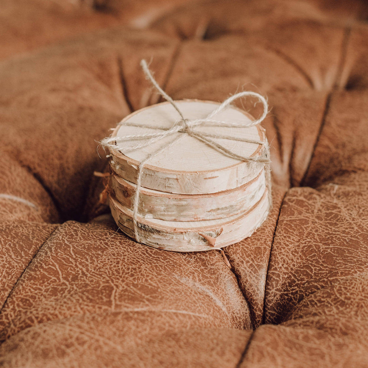 Small wooden container wrapped in twine on a textured brown surface