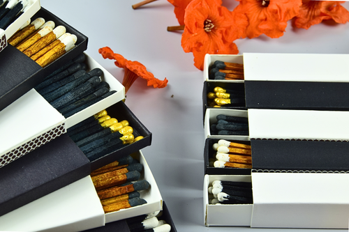 Matches in open and closed boxes with orange flowers in the background