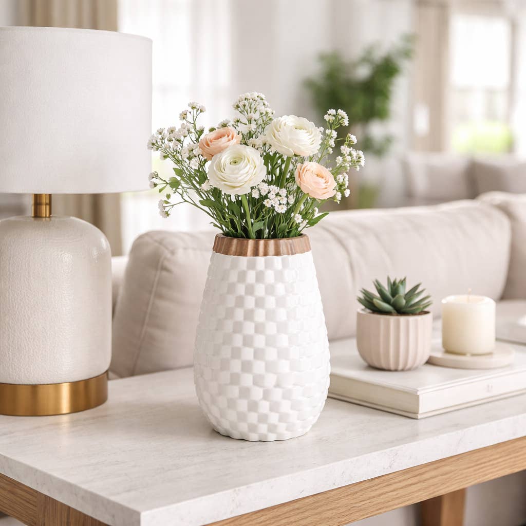 White vase with flowers on a coffee table in a living room setting