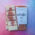 Iced Coffee (Coffee & Cream) soy wax melt snap bar in clear packaging with the Rainy Morning Candles label; white wax with coffee-brown swirls on a pink and blue background.