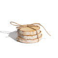 Stack of birch bark coasters tied with twine on a white background