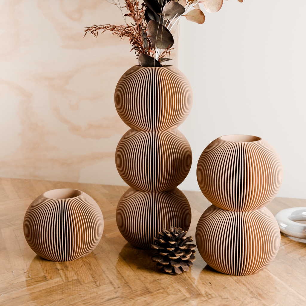 Stacked wooden vases on a wooden surface with a neutral background