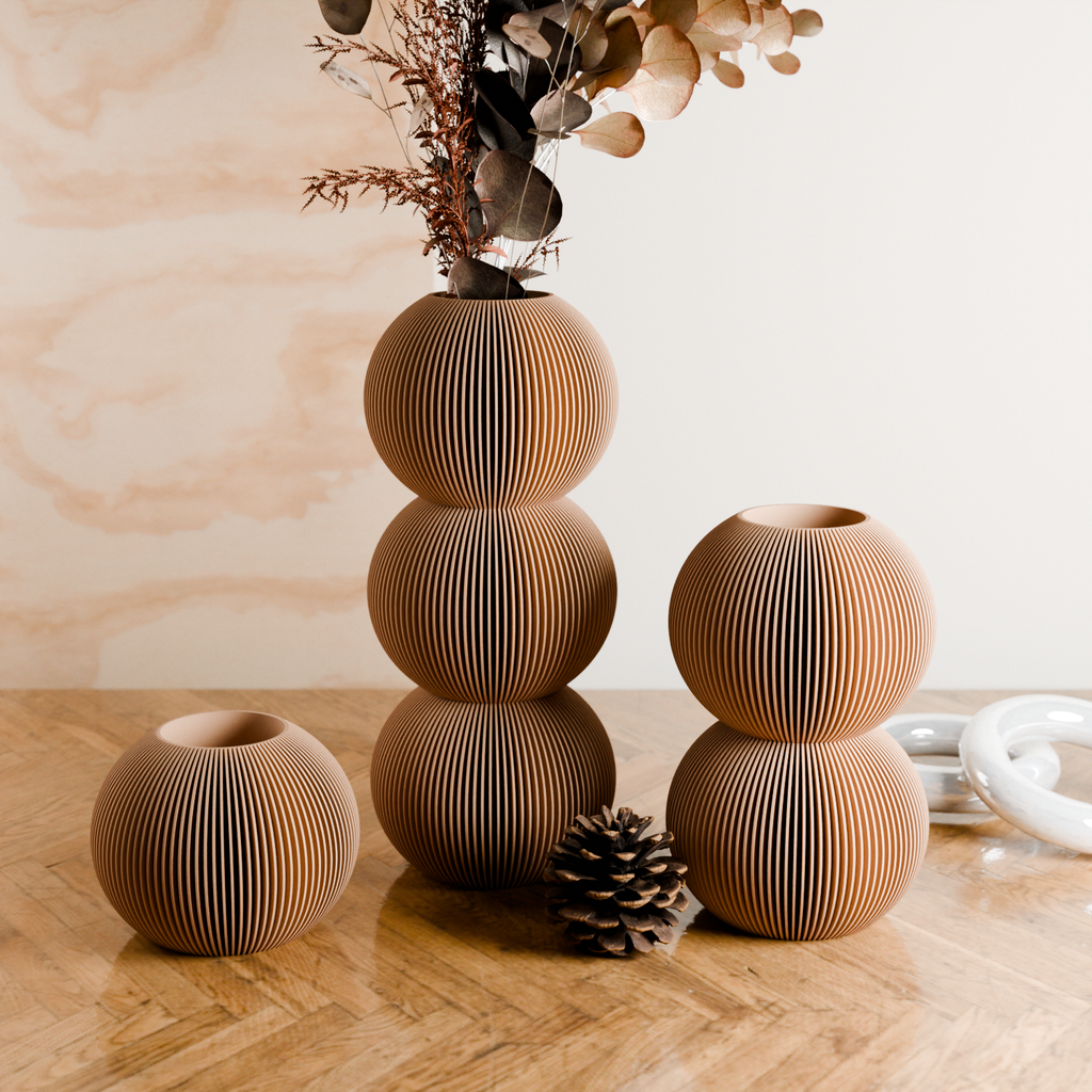 Set of three wooden vases on a wooden surface with a light background