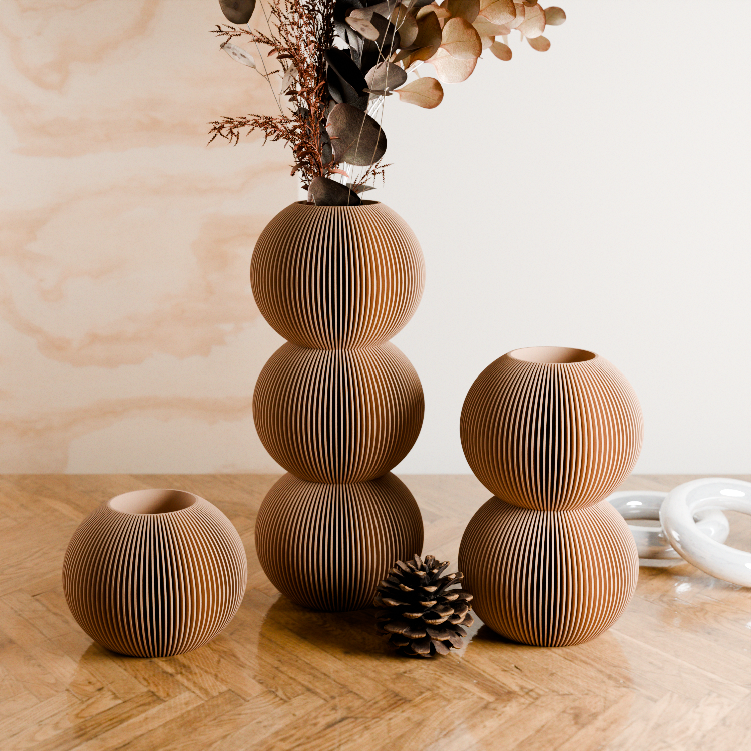 Set of three wooden vases on a wooden surface with a light background