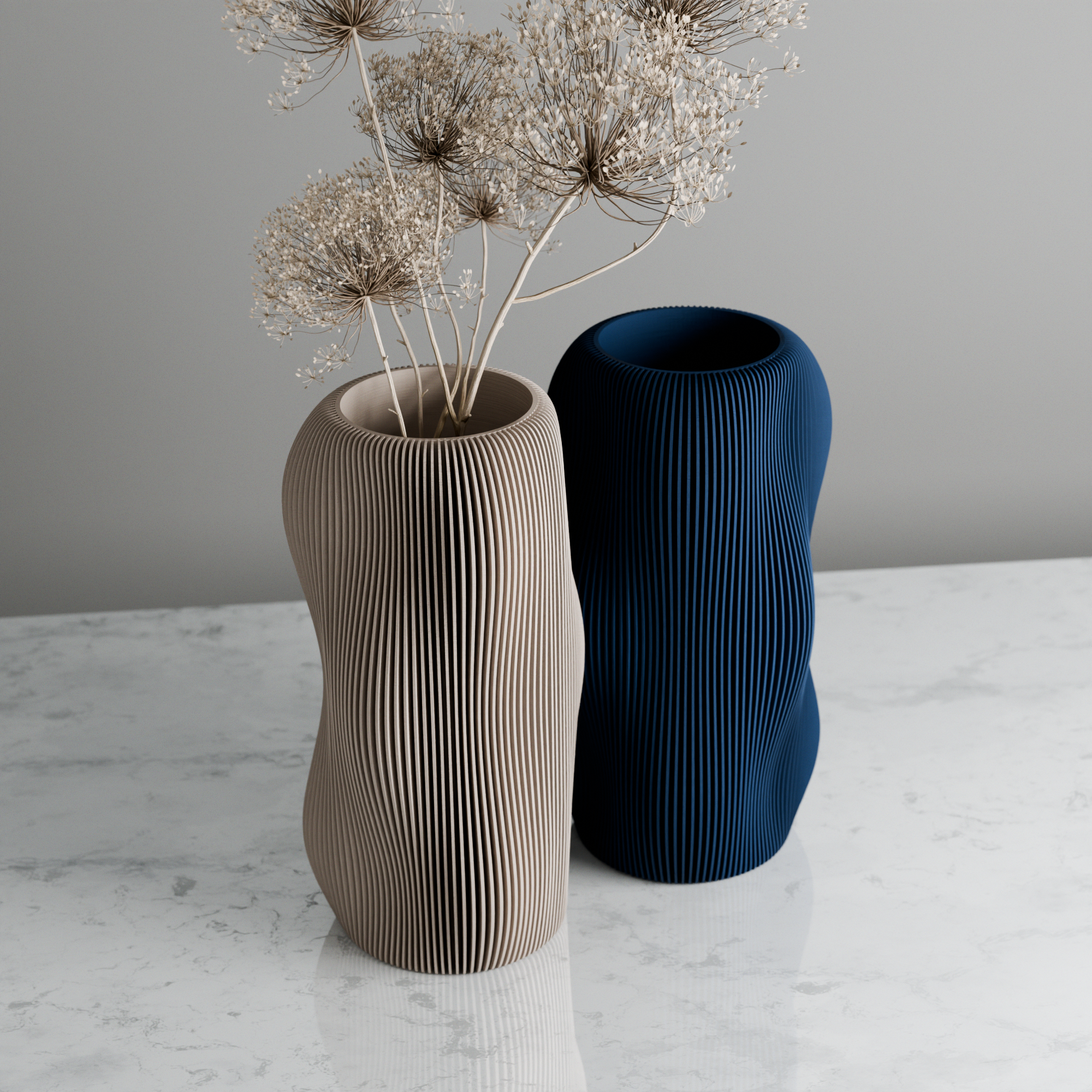 Two textured vases, one beige and one blue, on a marble surface with a gray background.