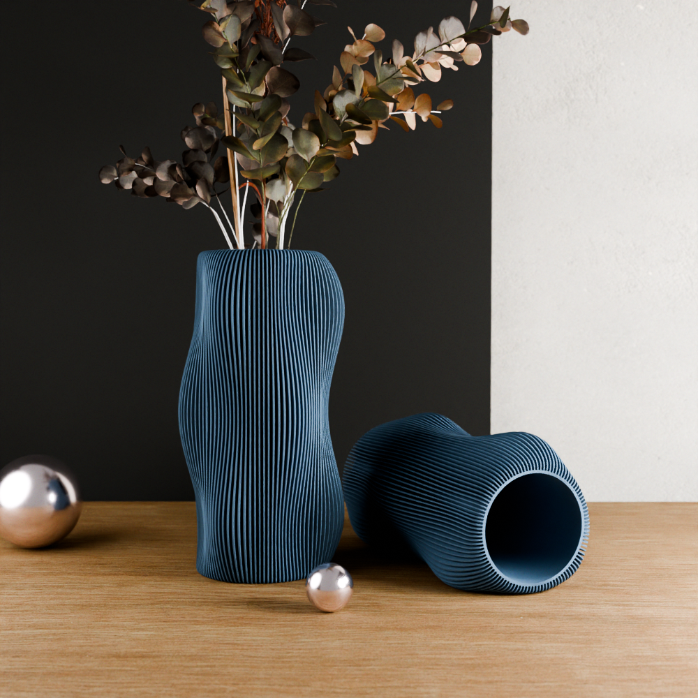 Blue textured vase with dried plants on a wooden surface against a black and white background