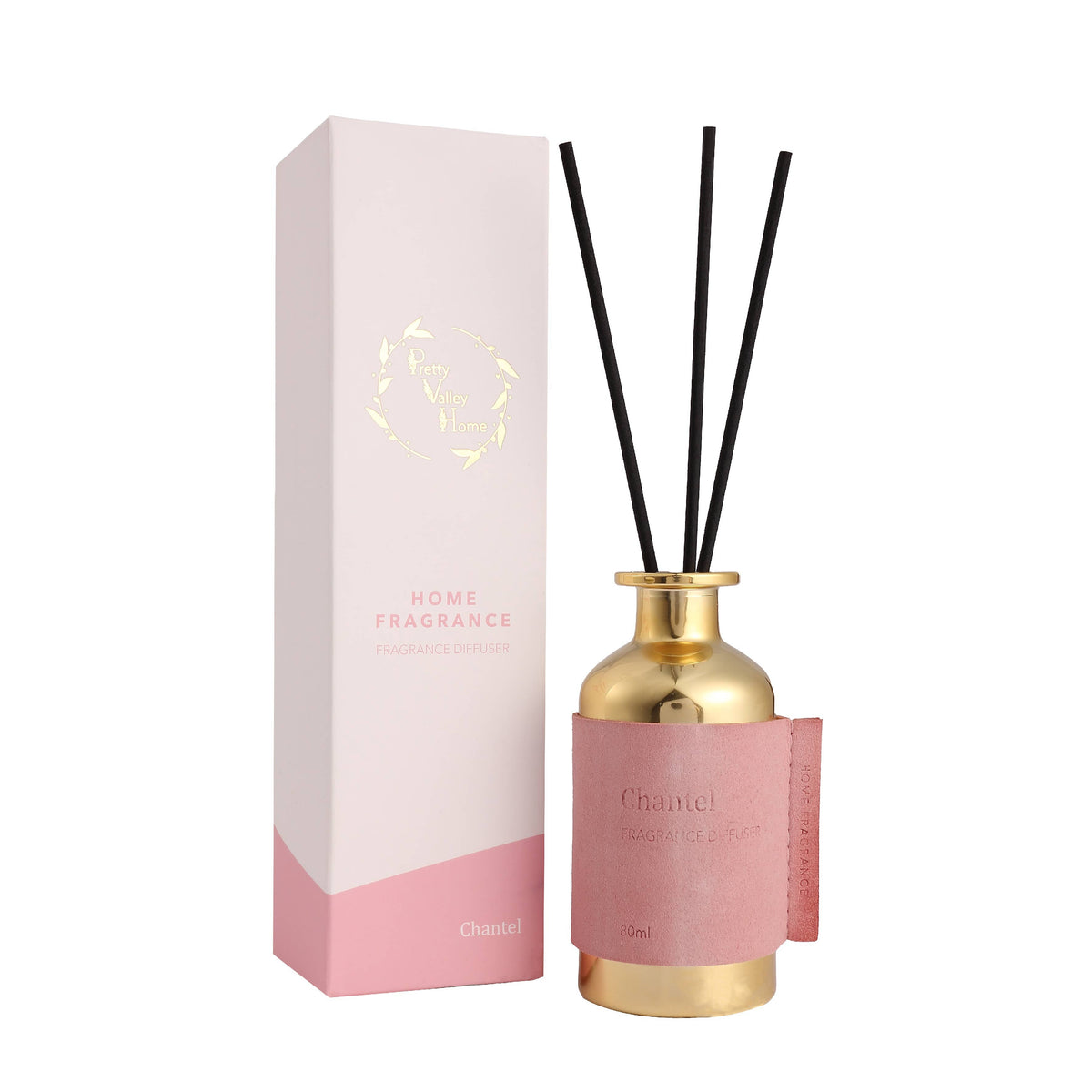 Chanel reed diffuser with a gold bottle, pink leather wrap, black reeds, and a matching pink and white box on a white background.