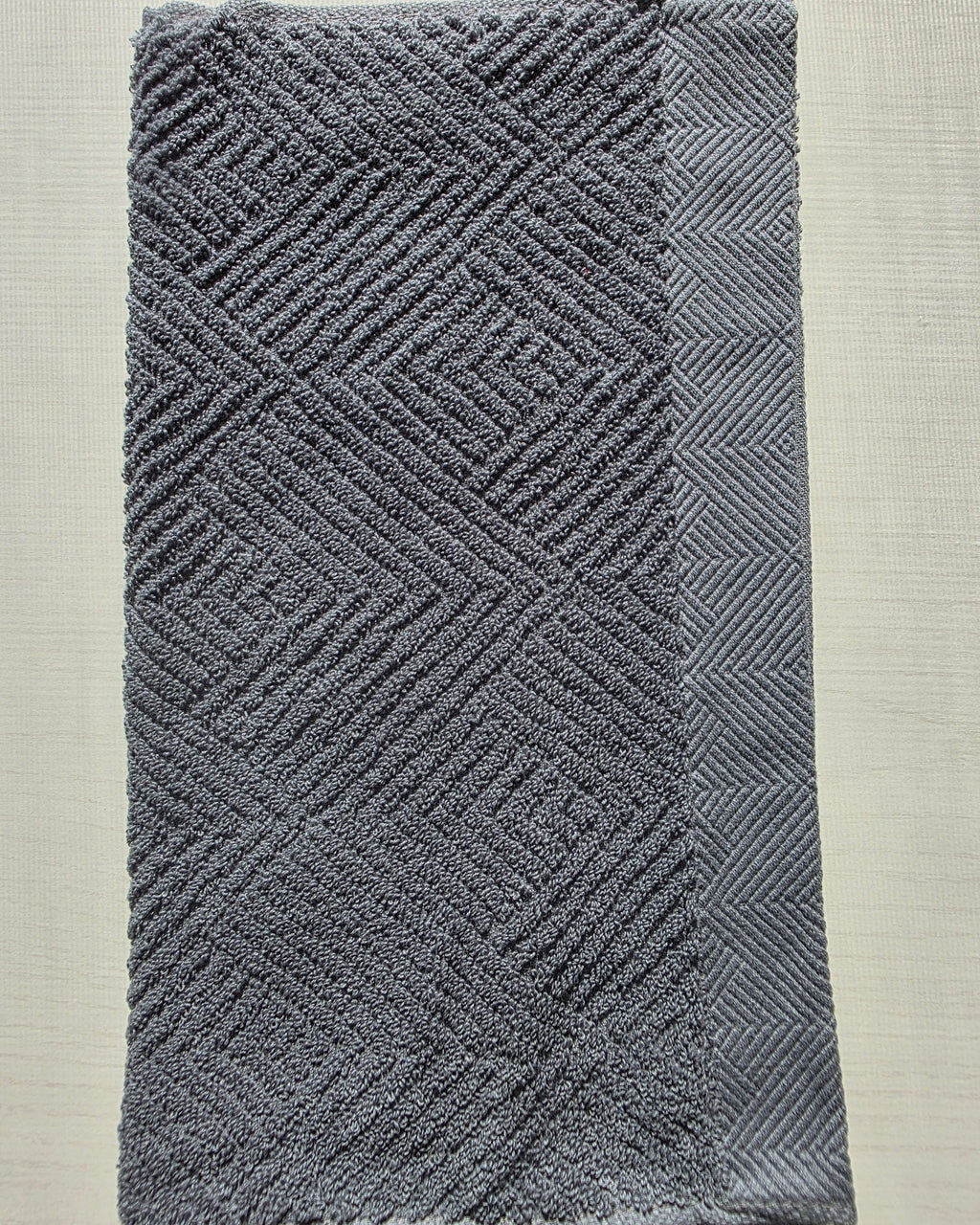 Close-up of dark gray cotton hand towel showing jacquard rhombus weave texture