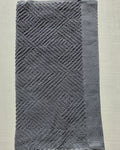 Close-up of dark gray cotton hand towel showing jacquard rhombus weave texture