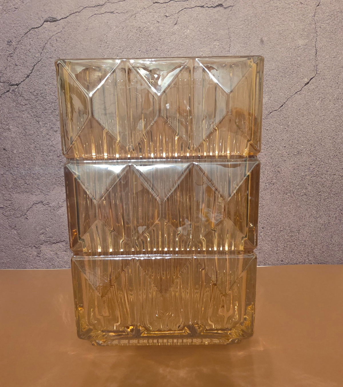 Close-up detail of amber square glass vase showing geometric diamond-cut ice-crackle texture