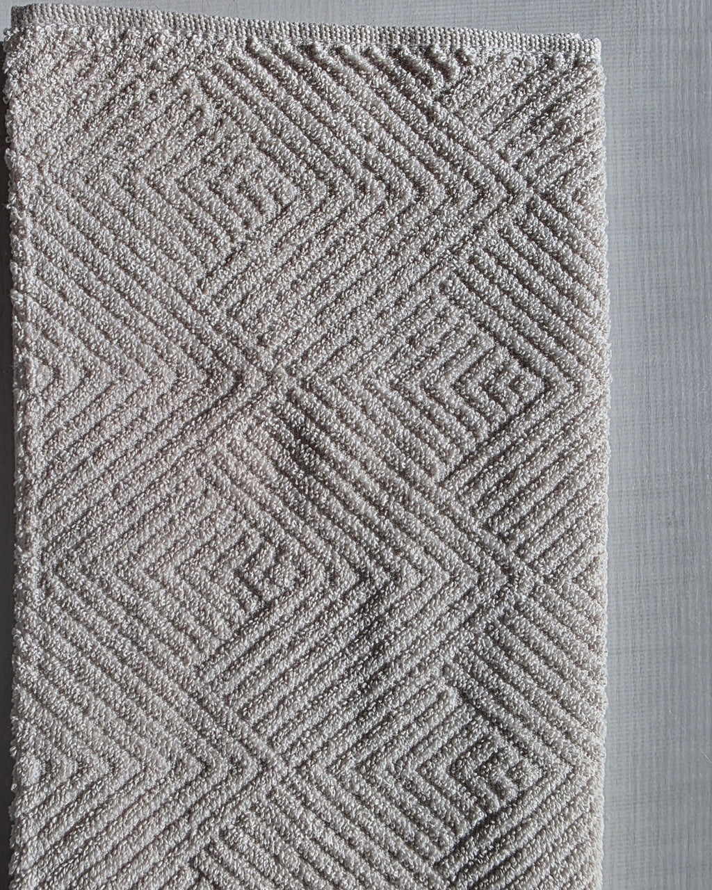 Close-up of ivory cream cotton hand towel showing jacquard rhombus weave texture