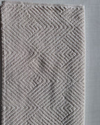 Close-up of ivory cream cotton hand towel showing jacquard rhombus weave texture