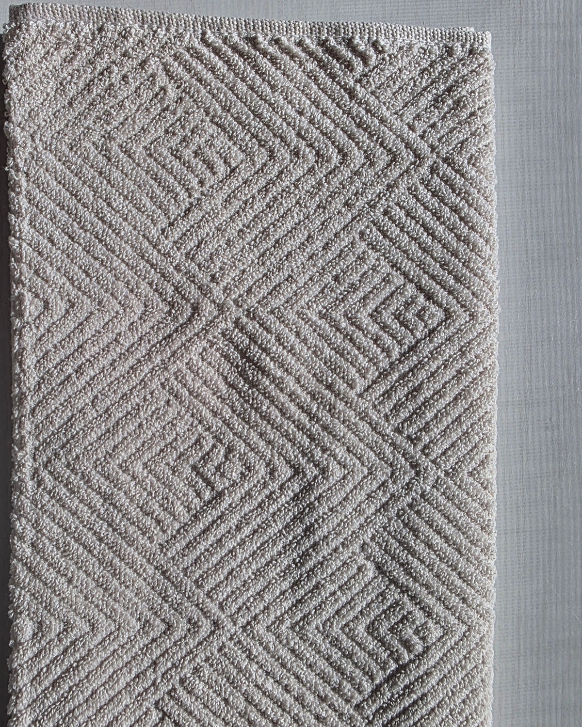 Close-up of ivory cream cotton hand towel showing jacquard rhombus weave texture