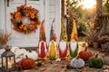 Harvest Home fall decor set: autumn wreath, four plush gnomes and velvet pumpkins on a porch at sunset