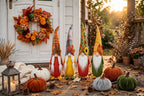 Harvest Home fall decor set: autumn wreath, four plush gnomes and velvet pumpkins on a porch at sunset