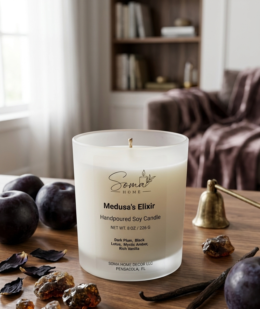 A handpoured soy candle in a frosted glass jar sits on a wooden table in a cozy living room setting. The candle is labeled 'Medusa's Elixir' by 'Soma Home Decor'.