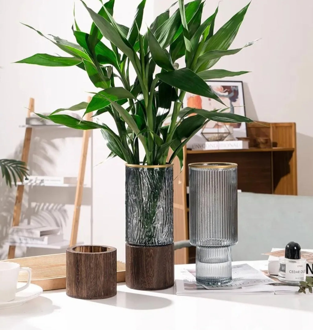 Ribbed and bark-textured glass vases with gold rims styled with a bamboo plant