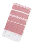 Folded red Turkish beach towel with white stripes and white tassels on white background