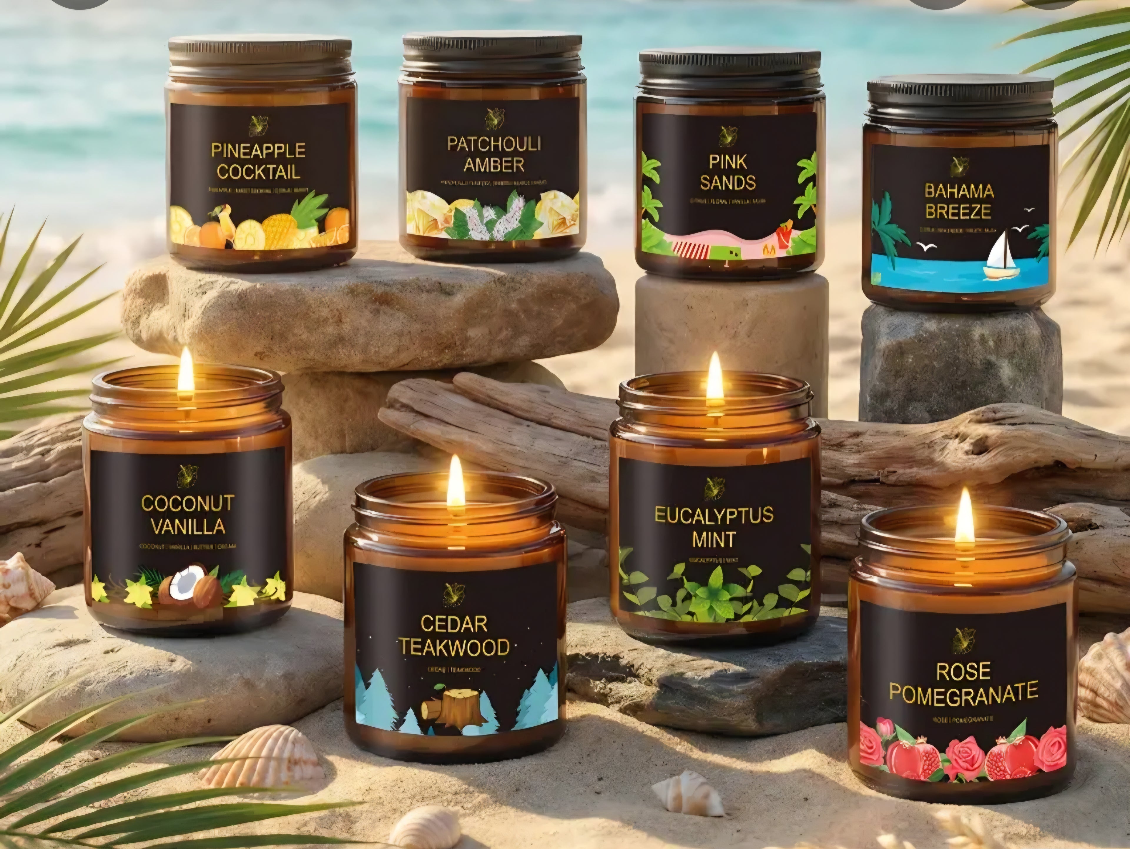 Six amber glass jar candles with black labels are arranged on driftwood and rocks at a beach, with tropical palm leaves and blue water in the background. The labels show different scent names: Pineapple Cocktail, Patchouli Amber, Pink Sands, Bahama Breeze, Coconut Vanilla, Cedar Teakwood, Eucalyptus Mint, and Rose Pomegranate.