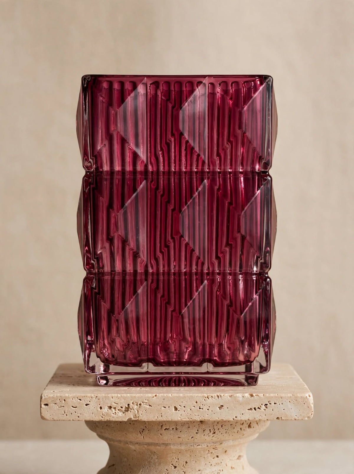 Magenta square geometric glass vase with ice-crackle texture, front view on a stone pedestal