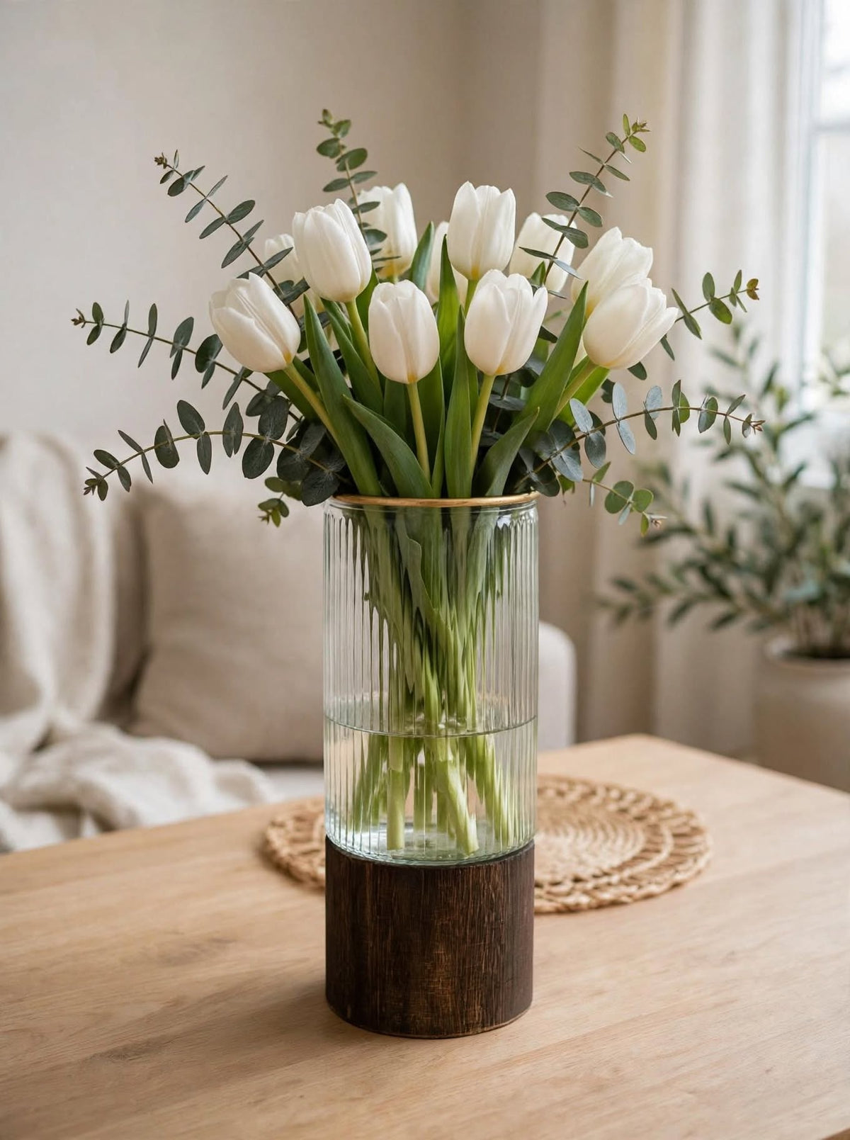 Clear ribbed glass vase with gold rim styled with white tulips and eucalyptus