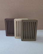 Eco-friendly Wood PLA soap savers standing in three neutral tones: brown, beige, and taupe.