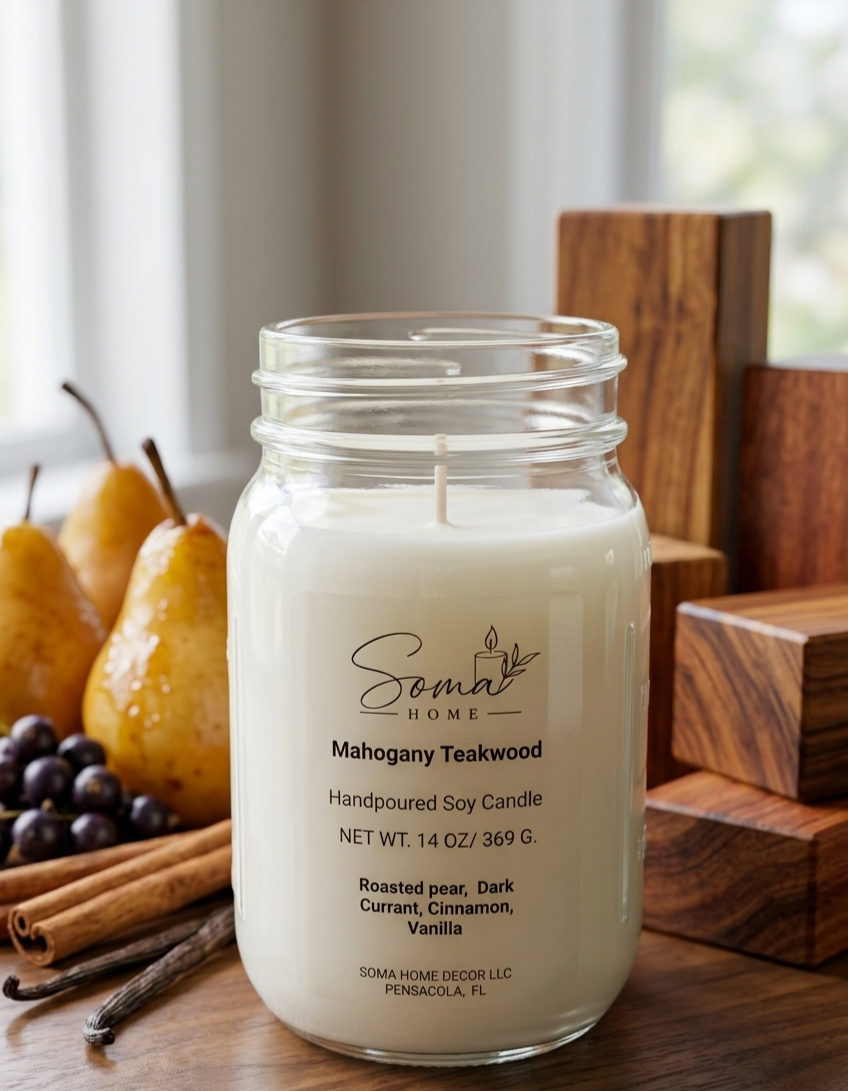 A handpoured soy candle in a clear glass mason jar by Somai Home, labeled Mahogany Teakwood, styled on a wooden table with pears, cinnamon sticks, and wood blocks in the background.