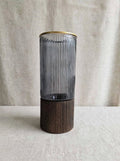 Smoky ribbed glass vase with gold rim on a wooden base, studio shot