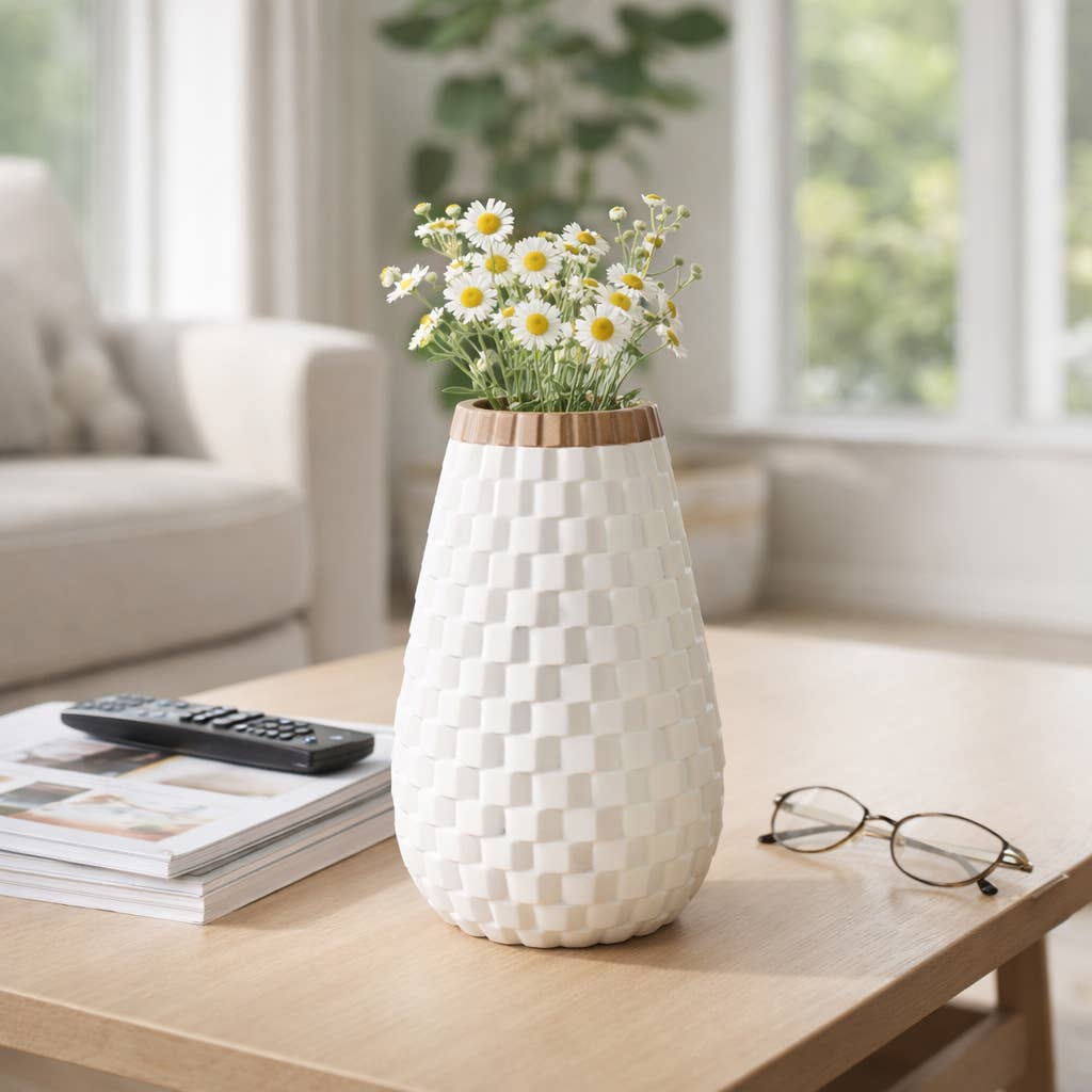 White woven-patterned vase with flowers on a coffee table in a living room.