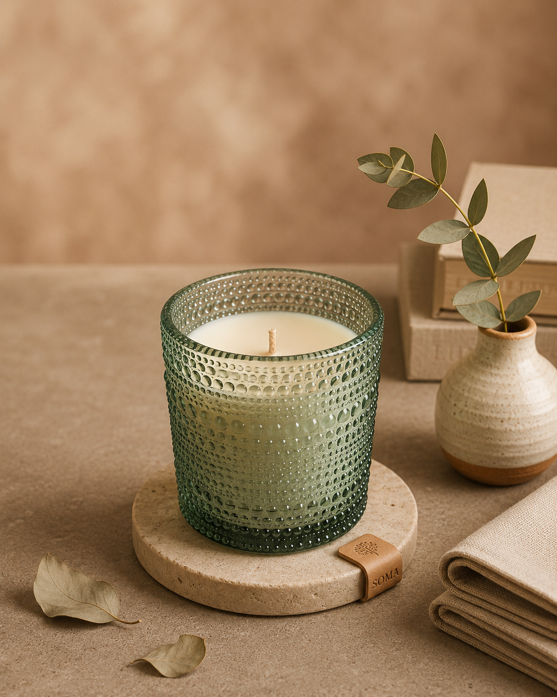 SOMA HOME Desert Bloom Scented Jar Candle with natural soy wax in a green textured glass jar, styled on a stone coaster with eucalyptus leaves.